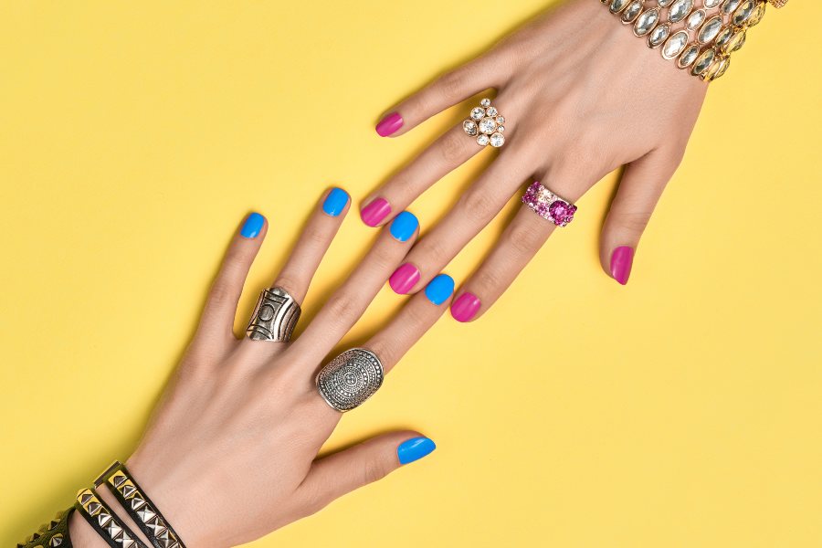 2 hands with acrylic nails and gel nails comparing polishes to each other